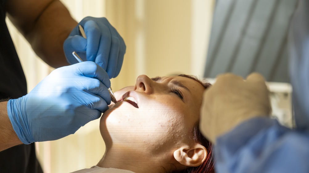 A smiling woman in Birmingham, Alabama, is showing off her perfect, white smile after getting porcelain veneers, highlighting the aesthetic results achievable with cosmetic dentistry. The image has text that says, "Veneers: Birmingham's Secret to a Perfect Smile."
